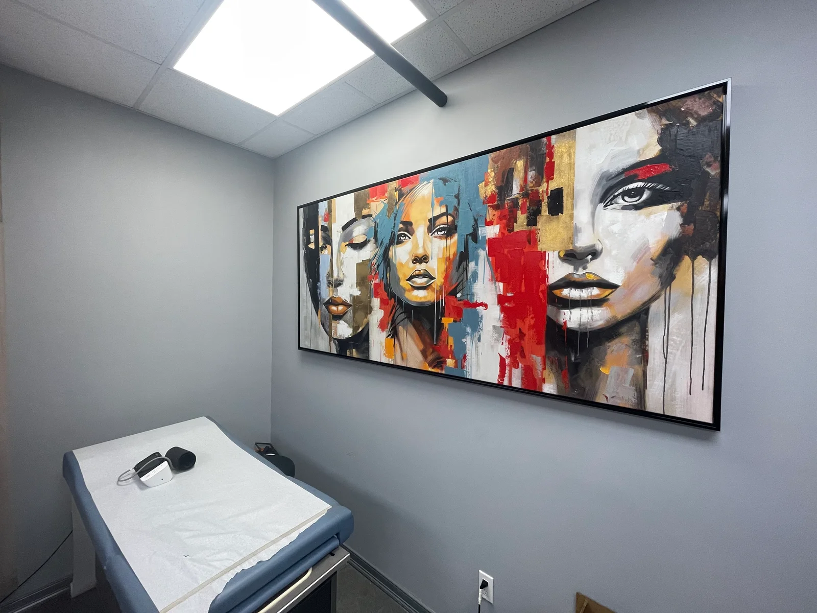 Ace Medical Care exam room with exam table and framed artwork